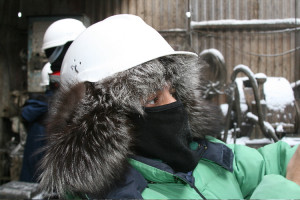 While in Siberia in minus 25 degrees Farenheit on an oil installation, Ken wears a fur-lined helmut while filming the workers drilling for natural gas.