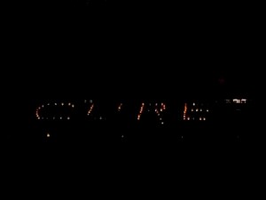 The word "CURE" lights the bleachers during the overnight event.  
