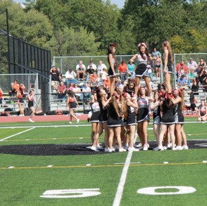 After spinning through the air, Cheerleader Juliana Roddy stands tall with the help of her teammates.
