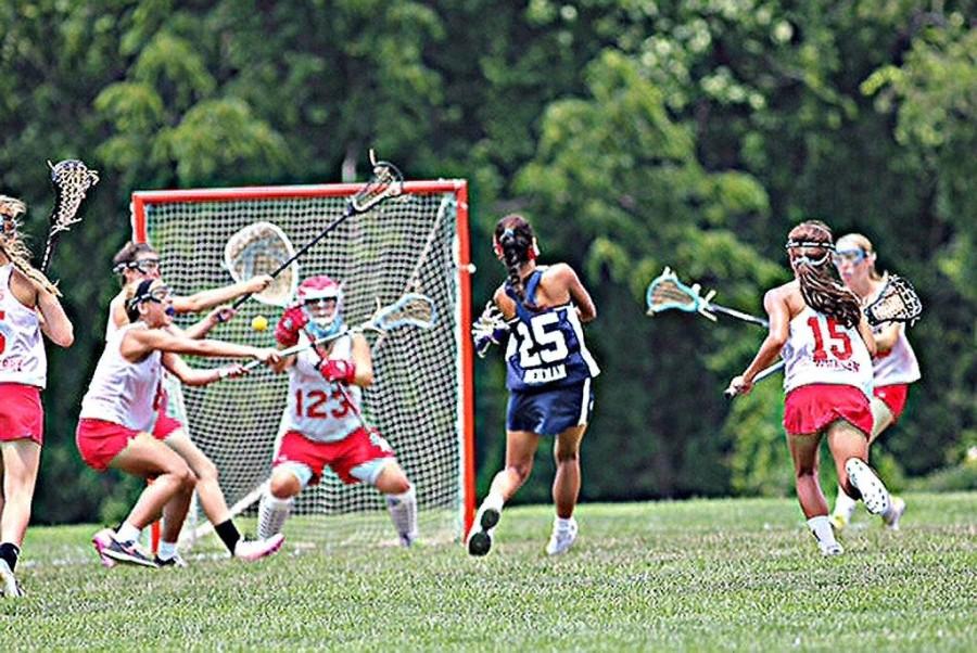 As she breaks through a swarm of defense, Alex Beilman scores a goal against her opponents.  