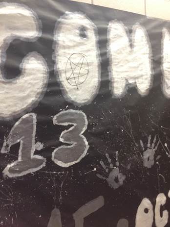 A homecoming poster, from October, vandalized with a pentagram symbol. Although recently discovered throughout the school, the pentagrams began earlier in the year. 