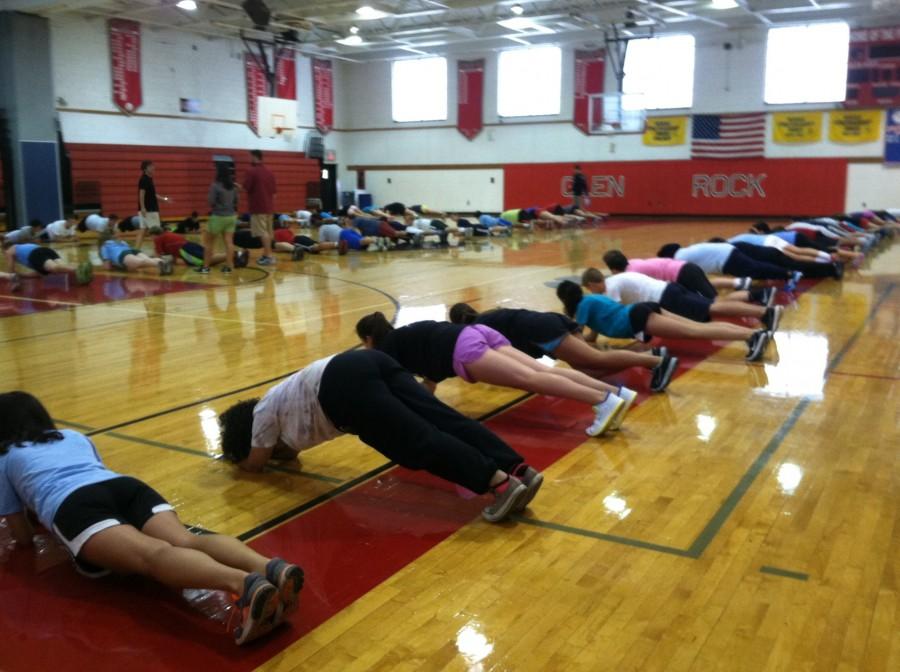 Physical Education students do planks for warm-ups. 