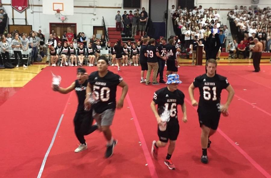 Football boys run off the mat after receiving their gifts from the cheerleaders