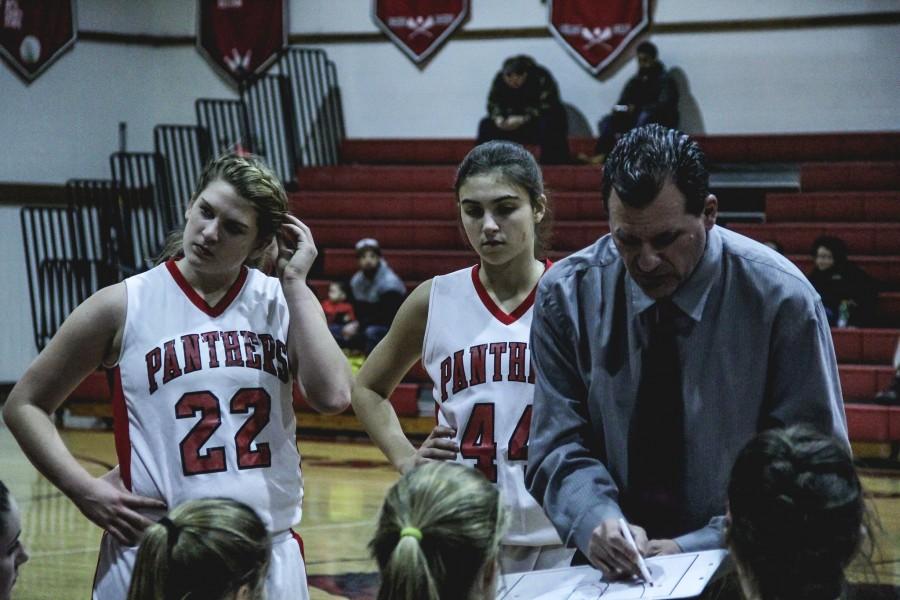 Kelly Lohr (17) and Cate McLoughlin (18) listen to Coach Steve Grenzs play to win the game.