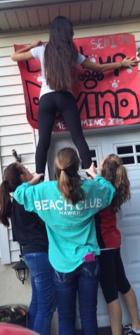 Christina and the JV team hanging up banners and signs for the exciting time of homecoming,