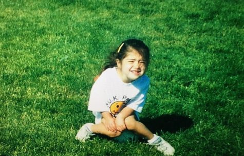 Julia sitting on a soccer ball at a young age during her beginning years of soccer.