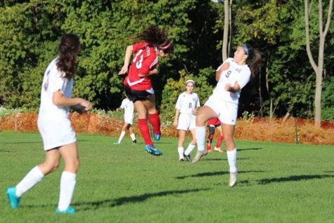Julia midair after a header during a game against Eastern Christian.