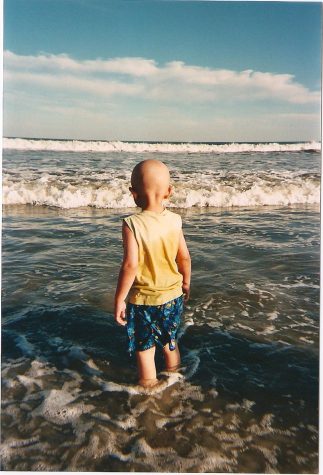Schwendeman feels the waves on his feet as he takes a trip to the beach with his family.