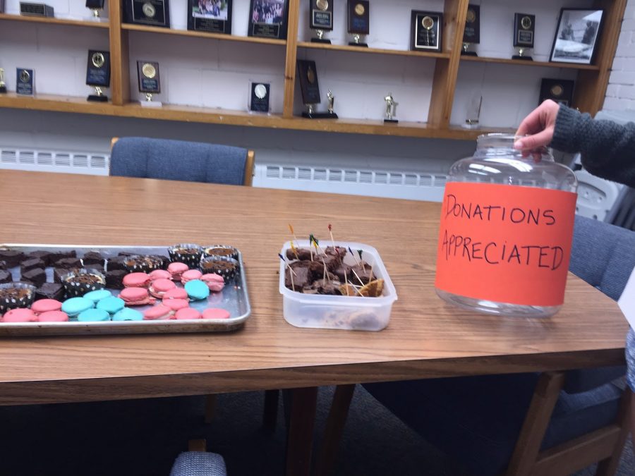Display of treats made for the bake-off with the donations bin beside them.