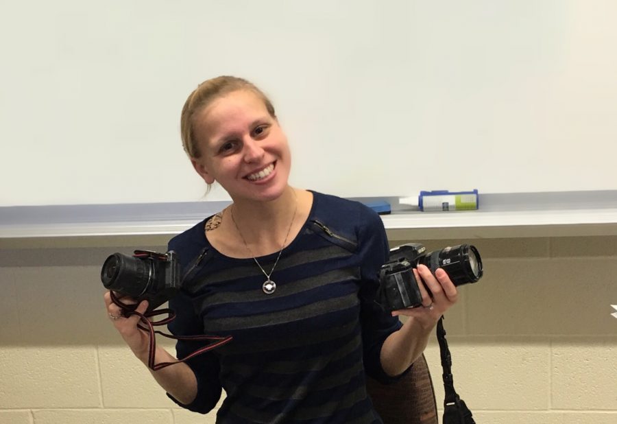 The newest photography teacher, Jenna Dunay poses with her two favorite cameras.
