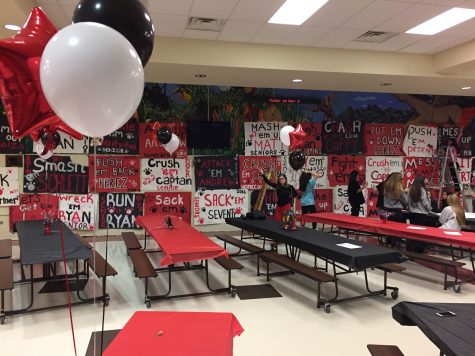 Varsity cheerleaders help put up their football players signs on Friday night before the 8 a.m. senior breakfast, Saturday morning. 