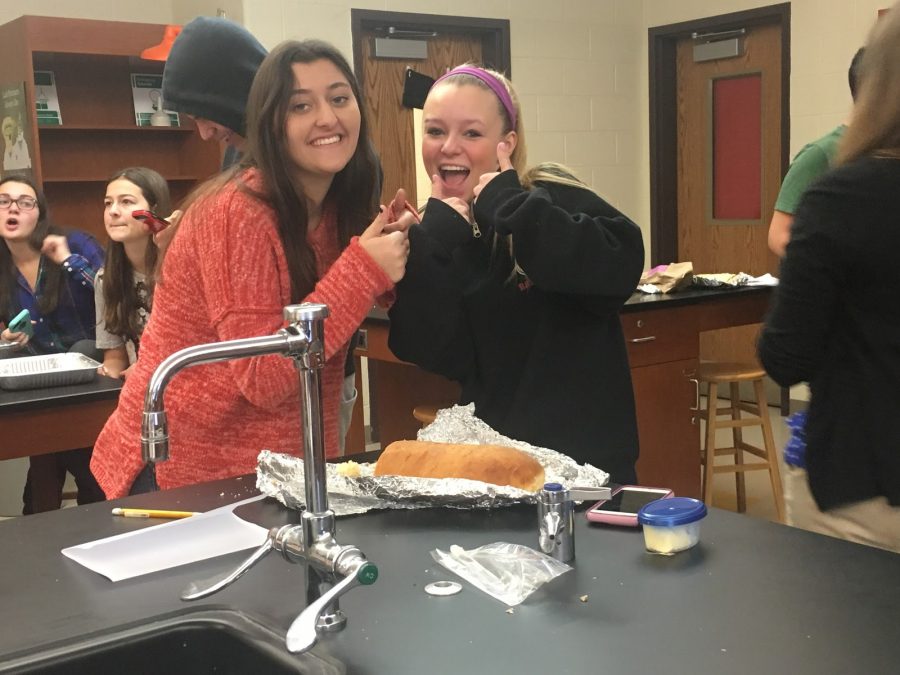 Freshman Lillie Daschil and Anna Rasmussen pose in front of their bread during judging.