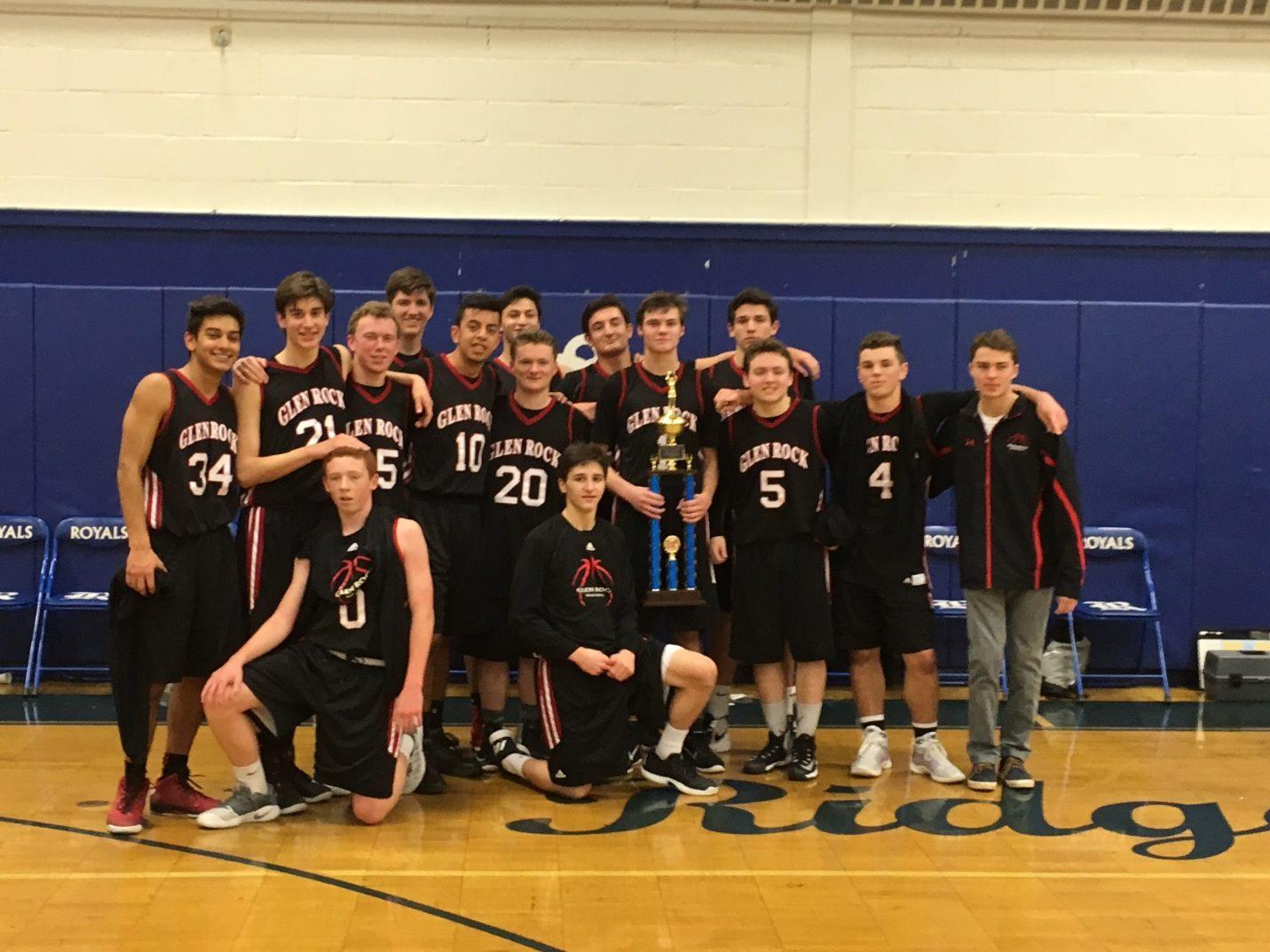 The boys basketball team following its holiday tournament win displays its trophy proudly. The team won for the second time in its history with the tournament, despite having only one returning senior.