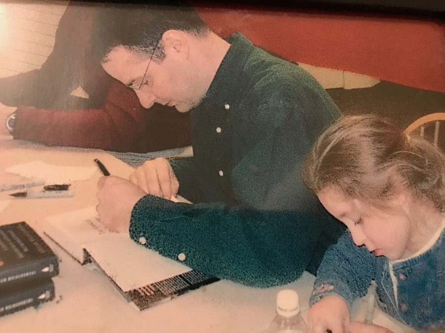 Leaving a mark on the opening pages of The Miracle of St. Anthony, author Wojnarowski signs his name. Alongside him sat his daughter, Annie Wojnarowski, uniquely signing her name as well.