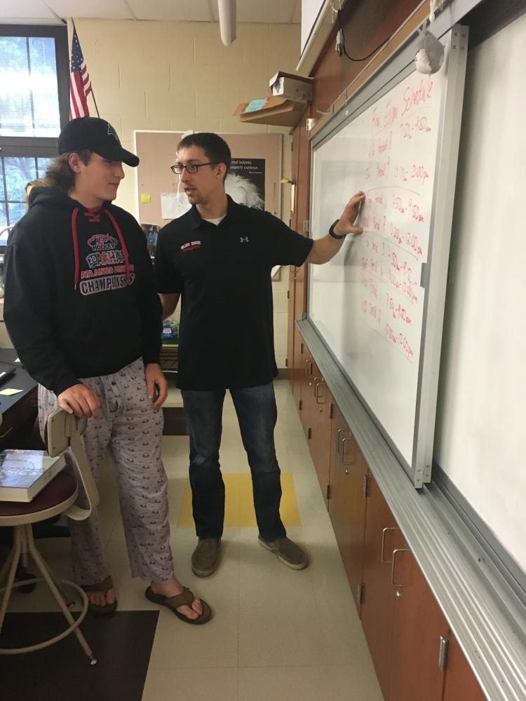 Teacher Brian Luckenbill teaches a science problem after returning from training with the National Guard.