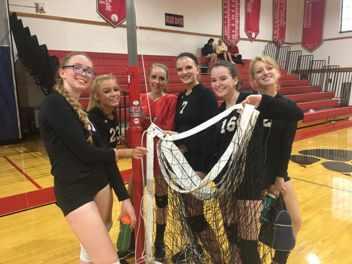 The girls hold up a net after their win against Lodi.