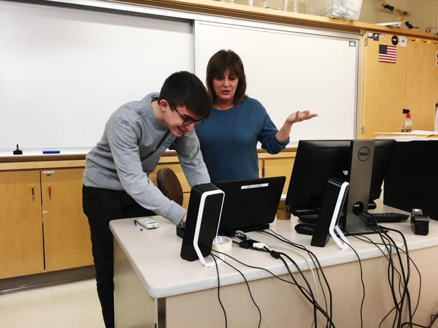 Michael Giardino (left) helps Una Kearns (right) with the computer during Marketing class.