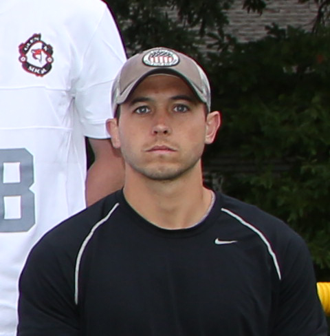 Coach Shick posing for the varsity soccer teams photo