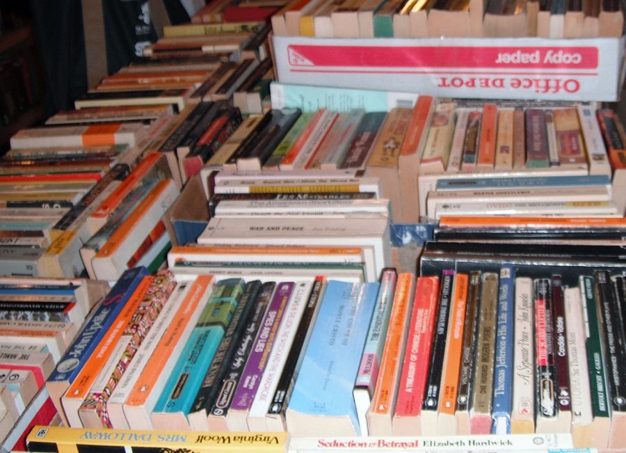 Boxes of books sit in a library book sale, waiting to be purchased. 