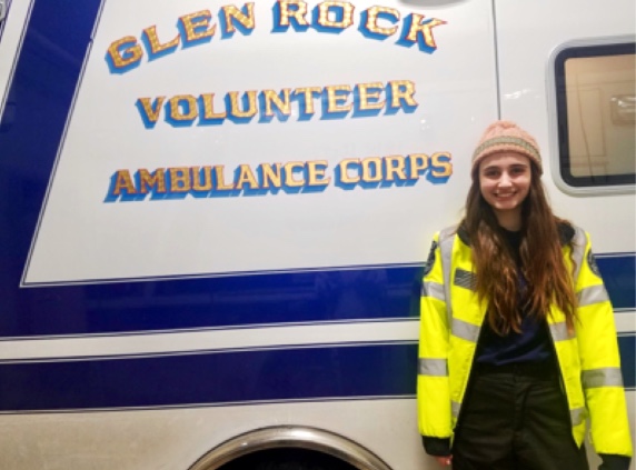 Emily Cornell smiles in front of one of Glen Rock ambulances. Cornell has been an EMT since October 2016.