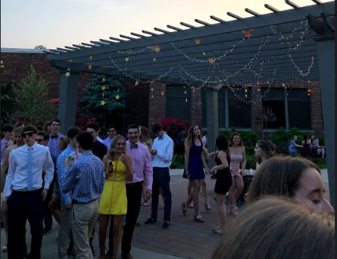 Students flourish under the courtyard pergola that is flooded with lights to match the dance’s theme.