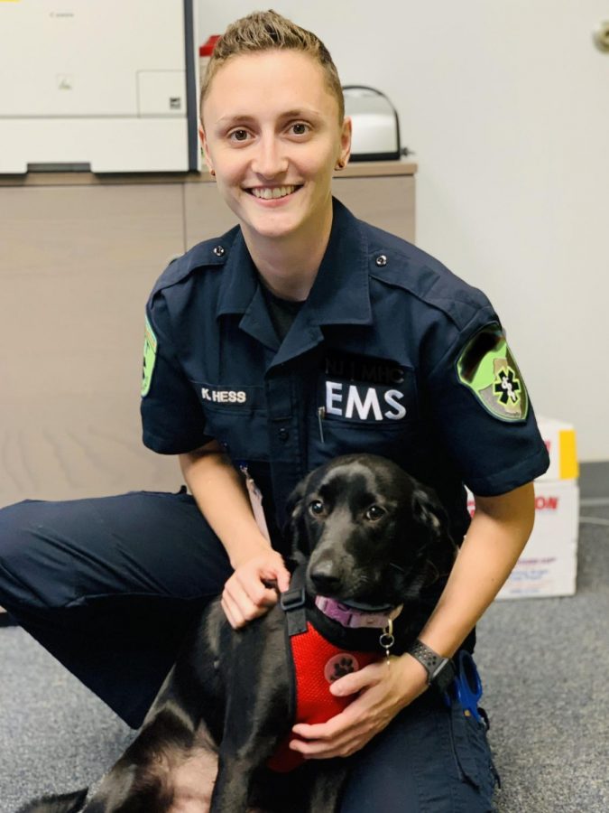 Kailyn Hess displays her EMT uniform with her dog. As a physical education and health teacher at the middle school, she aims to use her background as an emergency medical technician (EMT) to encourage younger generations to maintain a healthy lifestyle. 