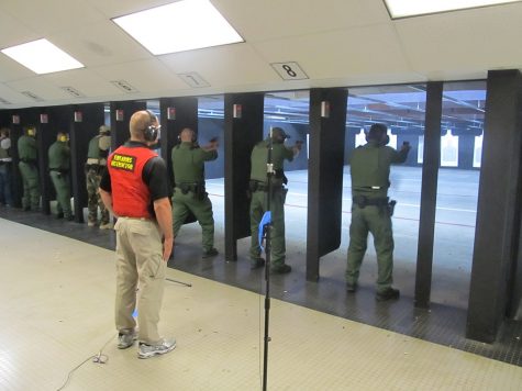 Federal law enforcement officers during firearms training exercises at indoor firing range