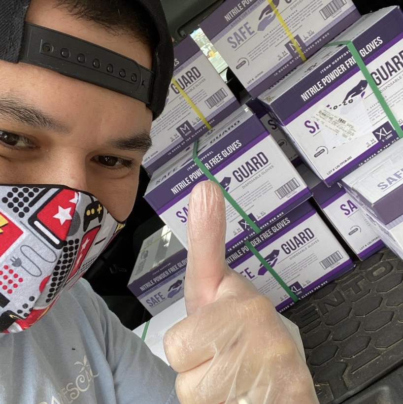 Owner Sal Reina takes a selfie in front of the the glove boxes that he will be donating to local hospitals. 