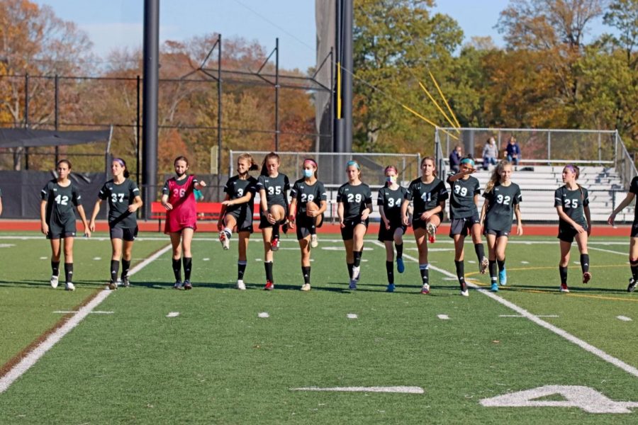 Before the JV girls soccer team verse Waldwick in a home game, they warm up together while maintaining acts of social distancing to prevent the spread of Covid-19.