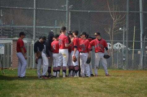 The Glen Rock High School Varsity Baseball team gathers in a huddle before they take the field.