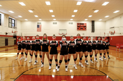 An intimidating portrait of the the whole volleyball team with their matching masks and their crossed arms shows their tenacity to not surrender their competitive nature despite COVID-19 derailing their season.