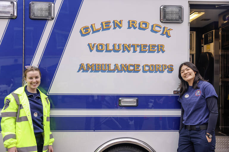Colleen Martin and Mia Vergel De Dios (Left to Right) in front of an EMT ambulance.